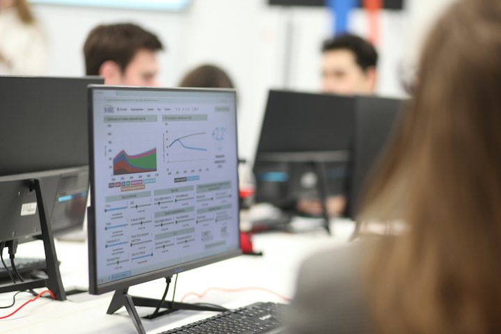 Equipe de análise trabalhando diante de monitores com gráficos
